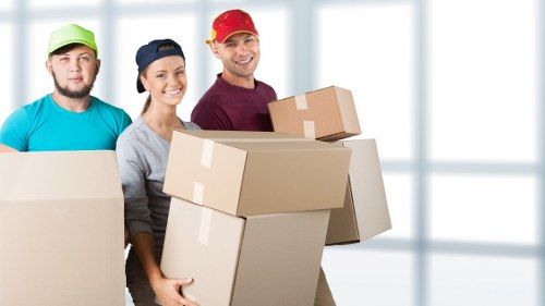 Removal team carrying items down narrow stairs in a Belsize Park property